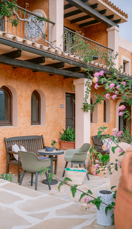 Rincón decorativo de Casa Naya Ibiza con cactus en maceta de barro y plantas suculentas sobre suelo de terracota.
